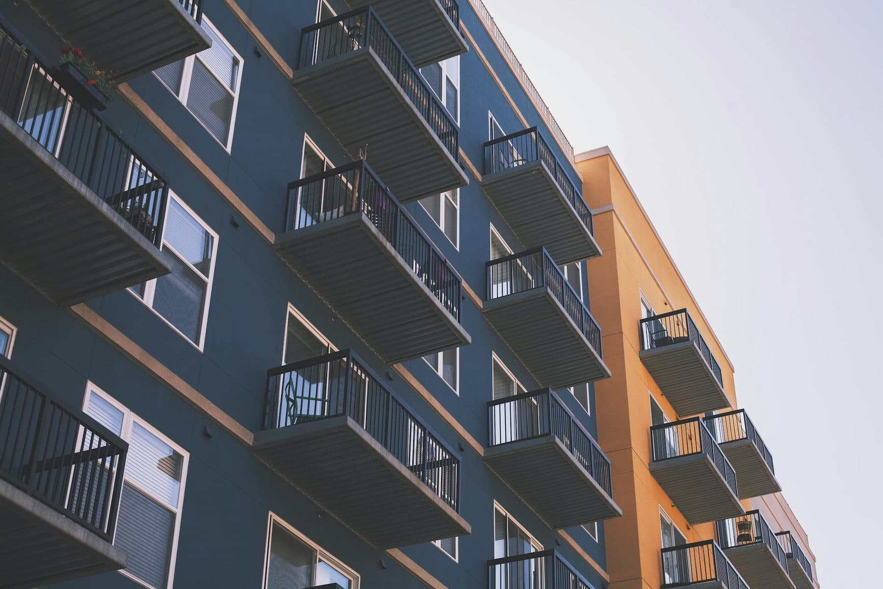 A modern multi-family apartment building with tiered balconies