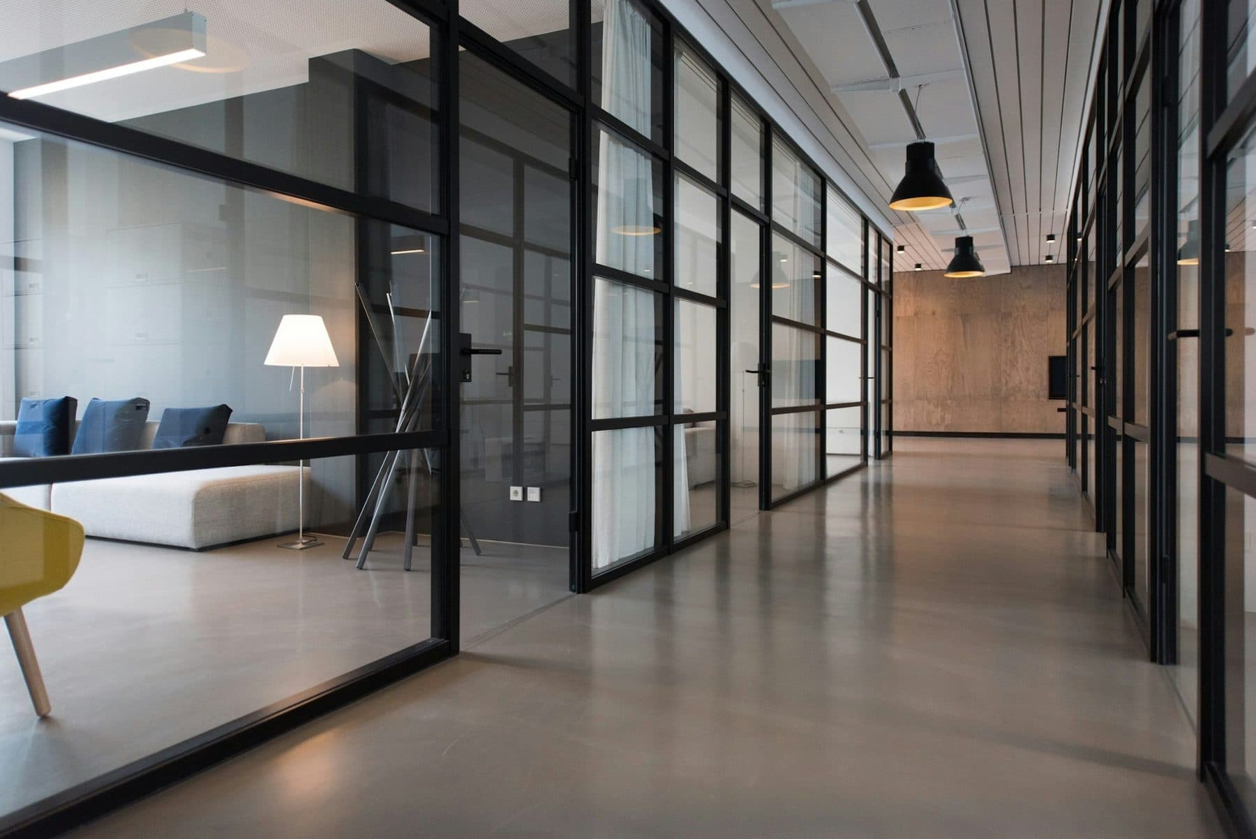 A modern property management office with glass-partitioned meeting rooms