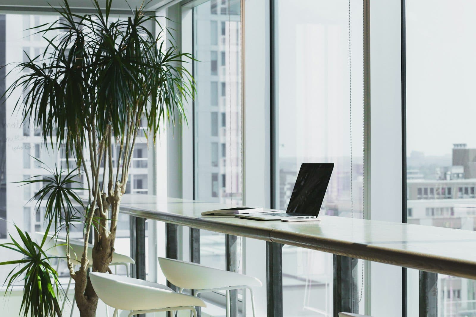 A bright modern office overlooking the city, with a laptop open on the desk